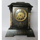 An early 20thC marble and black slate cased mantel clock, flanked by two Corinthian capital pillars,