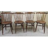 A set of four early 20thC beech framed comb and spindled back kitchen chairs,