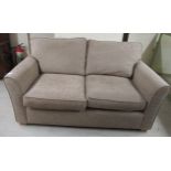 A modern two seater settee with a level back,
