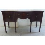 An early 20thC reproduction of a Regency mahogany serpentine front sideboard with a central drawer,