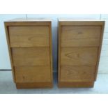 A pair of 1970s teak, three drawer bedside chests,