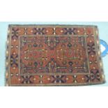 A Persian rug decorated with repeating designs on a red ground 36'' x 54'' U