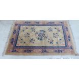 A Chinese washed woollen rug, decorated with traditional designs,