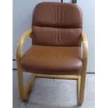 A modern beech framed office chair, upholstered in cushioned tan coloured hide,