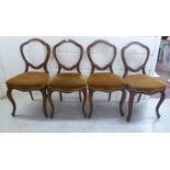 A set of four late Victorian walnut framed balloon back dining chairs with fabric upholstered seats,