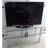 A Celcus 40'' television with a remote control, on a three tier, glazed stand 20.