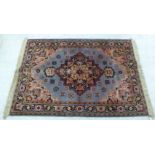 A Persian woollen rug, decorated with symmetrical flora and other designs,