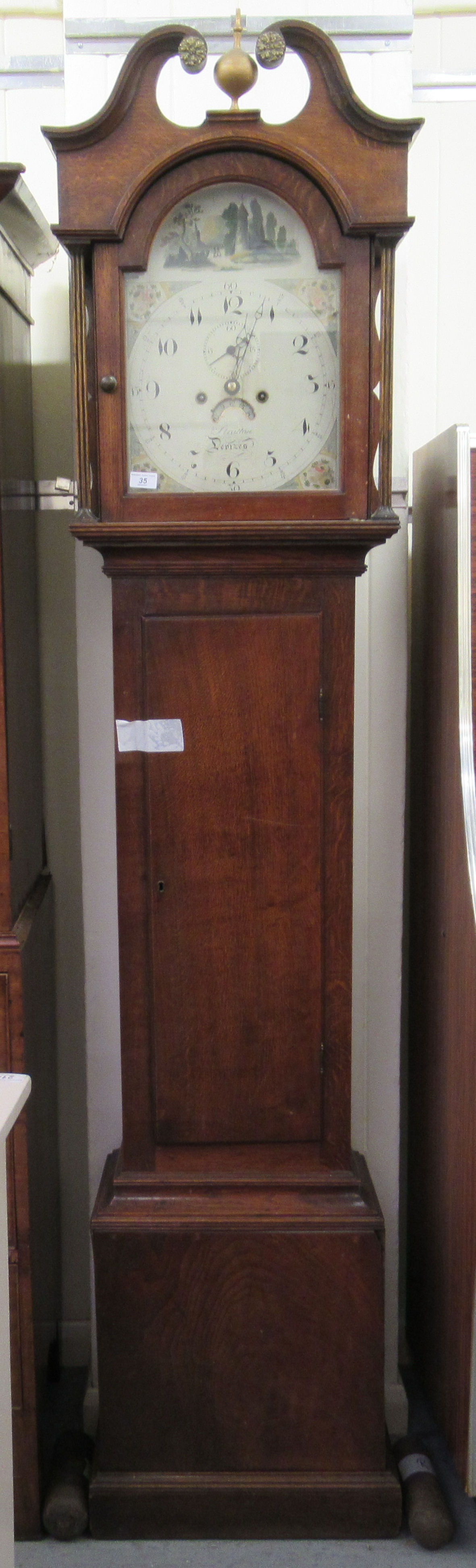 A late 18th/early 19thC oak longcase clock, the hood with a swan neck pediment and a waisted trunk,