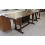 A mid 20thC oak refectory table, raised on four square supports,
