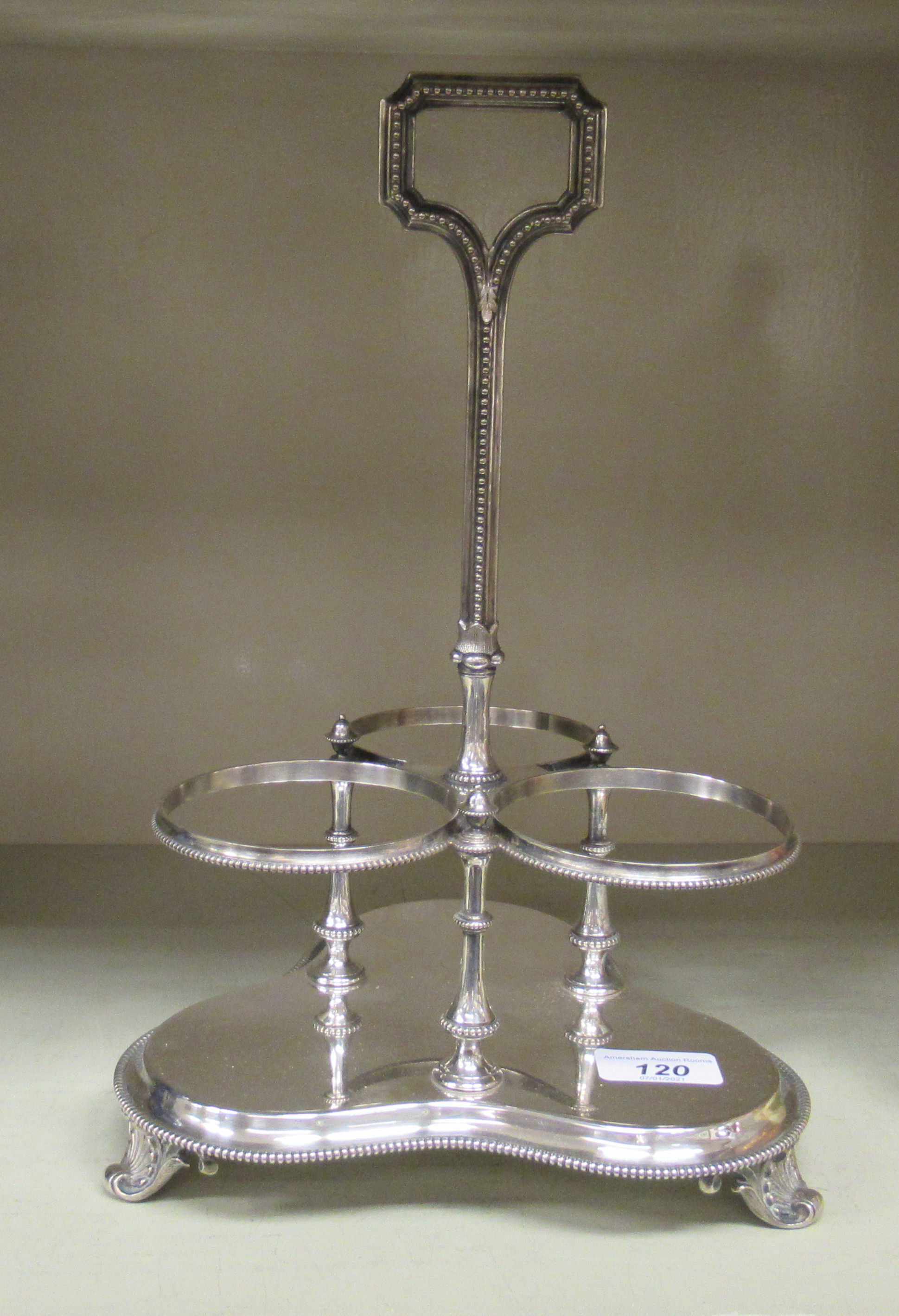 A Victorian silver plated bead bordered table tantalus with a central handle and three conjoined