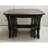 A nesting set of three Ercol dark stained beech and elm occasional tables largest 16.