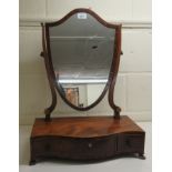 An Edwardian string inlaid mahogany toilet mirror, the shield shaped plate on a serpentine front,