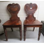 A pair of Regency mahogany framed hall chairs, the solid seats raised on ring turned,