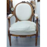 A modern beech showwood framed open arm chair, the fabric upholstered seat raised on tapered,