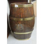 A late 19thC coopered oak barrel with brass riveted mounts and a painted armorial BSR