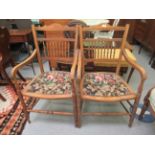 A pair of Edwardian oak framed, open arm chairs with bobbin turned,