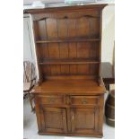 A 20thC oak dresser with a two tier plate rack with two drawers, over two panelled doors,