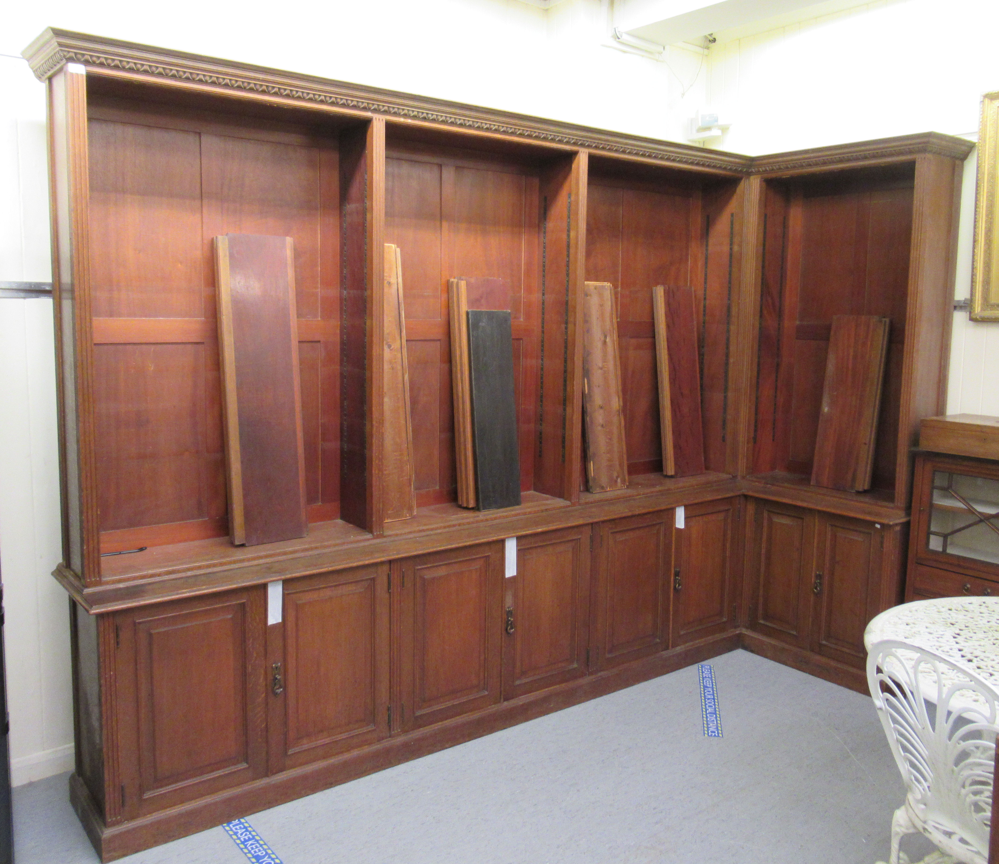 An Edwardian oak L-shaped library bookcase, having a moulded cornice,