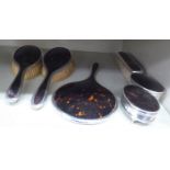 A six piece silver and tortoiseshell mounted dressing table set, comprising a pair of hair brushes,