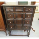 A mid 20thC stained oak tallboy with four equal drawers and bun handles, raised on knopped,