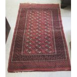 A Bokhara rug, decorated with three columns of twelve guls, bordered by stylised designs,