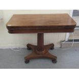 A late Regency mahogany card table, the baize lined rotating, foldover top raised on a tapered,