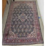 A Persian rug, decorated with a central medallion, surrounded by repeating designs,