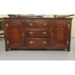 A mid 20thC oak sideboard, the three central doors flanked by twin fielded panelled doors,