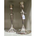 A pair of loaded white metal candlesticks of oval,