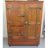 An early 20thC panelled and polished freestanding ice cabinet, the three doors with iron fittings,