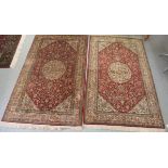 A pair of 90% silk 10% cotton rugs, profusely decorated with stylised flora and foliate designs,