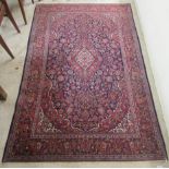 A Persian rug, profusely decorated with flora and foliage,