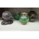 Two dissimilar late Victorian coloured glass inkwells with decoratively cast brass caps;