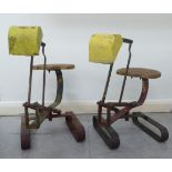 A pair of children's mid 20thC wrought iron framed toy sit-on sandpit diggers with twin lever