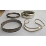 Three dissimilar silver hinged bangles and another 11