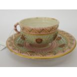 A Royal Worcester reticulated china cabinet cup and saucer with gilded pastel coloured ornament