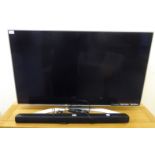 An LG Super UHD 48" flatscreen television with remote control and sound bar