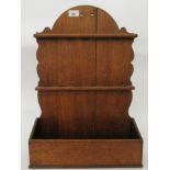 A 19thC country made, planked, honey coloured oak, hanging spoon rack, over an open compartment