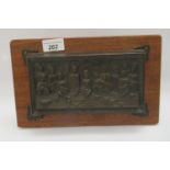 A cast and patinated bronze plaque, depicting The Last Supper  5" x 9", on a mahogany backplate