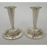 A pair of Continental silver coloured metal candlesticks with tapered octagonal stems, on loaded