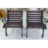 A pair of Victorian style slatted teak terrace armchairs with C-scrolled cast iron supports