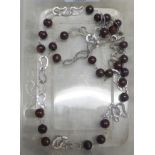 A pearl and silver coloured metal multi ring linked designer necklace