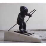 A mid 20thC cast bronze model, a skier, on a sloping marble plinth  4.75"h