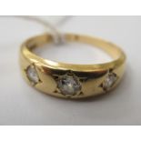 An 18ct gold three stone, rubover set diamond ring