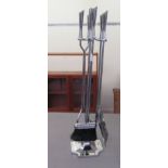 A chromium plated fireside companion, the four implements set on an incurved, square stand