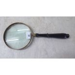 An oversized magnifying glass, on a turned wooden handle  15"h