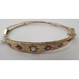 A late Victorian yellow metal bangle, set with diamonds and rubies