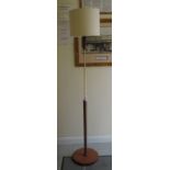 A mid 20thC Danish inspired design floorstanding lamp with a brass column, on a teak pillar and