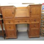 An Ercol light oak, twin pedestal bureau desk with a central fall-flap, enclosing pigeon hole