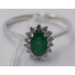 An 18ct white gold claw set, emerald and diamond cluster ring